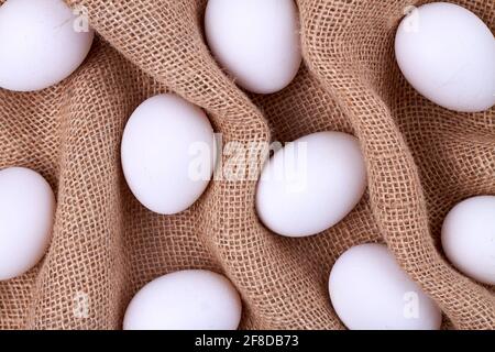 Weiße Eier auf einem zerknittert gewebten Tuch. Stockfoto