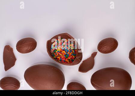 Braunes Choco-Ei, gefüllt mit Regenbogenstreuseln. Stockfoto