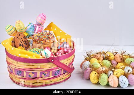 Hausgemachte osterkuchen im Korb und handbemalte Eier. Stockfoto