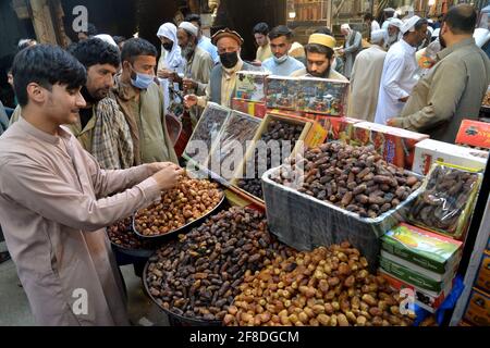 Peshawar. April 2021. Die Menschen kaufen Datteln auf einem Markt vor dem Fastenmonat des Muslims Ramadan im nordwestlichen Pakistans Peshawar am 13. April 2021. Der Ramadan-Halbmond wurde am Dienstagabend in Pakistan gesichtet, und der heilige Monat wird offiziell am Mittwoch beginnen, so eine offizielle Ankündigung des Mondsichterkomitees des Landes. Quelle: Umar Qayyum/Xinhua/Alamy Live News Stockfoto