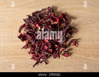 Trockene rote Hibiskusblüten auf einem Holztisch Stockfoto