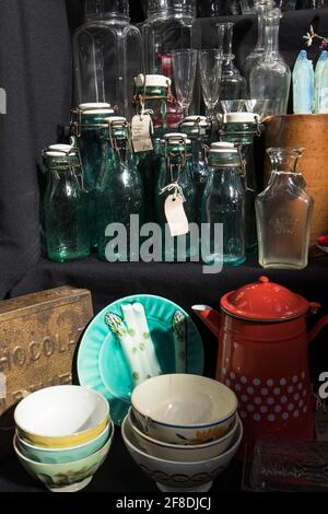 London, UK - 20. September 2020 Glasflaschen mit Korken, staubigen Weingläsern, Dose Kaffeekannen, Steingutteller auf der Theke im Herzen von New York zu verkaufen Stockfoto