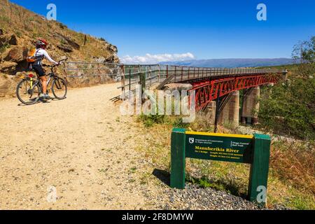 Radfahrer überqueren die Manuherikia River Brücke auf dem Otago Central Rail Trail, Otago, South Island, Neuseeland Stockfoto