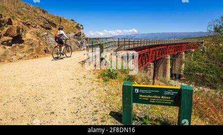 Radfahrer überqueren die Manuherikia River Brücke auf dem Otago Central Rail Trail, Otago, South Island, Neuseeland Stockfoto