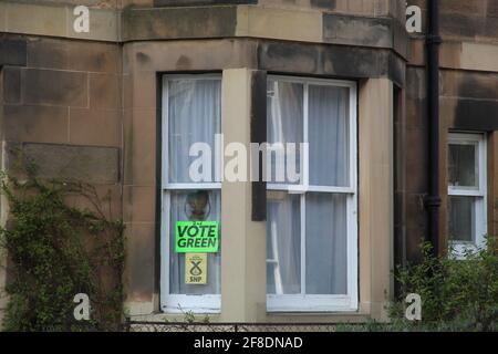 Stimmen Sie während der Abstimmung auf einem Hausfenster auf Green- und SNP-Plakate ab Die schottische Wahlkampagne 2021 Stockfoto