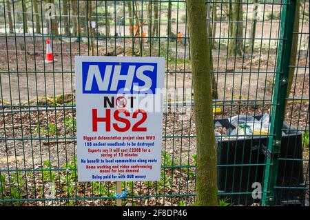 Aylesbury Valle, Großbritannien. April 2021. Ein NHS nicht HS2 Zeichen im Wald. HS2 waren zurück in den alten Wäldern von Jones Hill Wood heute fällten Bäume. Umweltaktivisten, die versuchen, Jones Hill Wood zu schützen, ergreifen rechtliche Schritte gegen Natural England, das die Lizenz an HS2 Fell Jones Hill Wood erteilt hat, obwohl es seltene Barbaren Fledermäuse im Holz hat. Die umstrittene und massiv über den Budget verfegte High Speed 2-Bahnverbindung von London nach Birmingham macht eine riesige Narbe über die Chilterns, die eine AONB ist. Quelle: Maureen McLean/Alamy Stockfoto