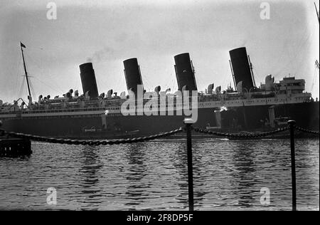 AJAXNETPHOTO. 1931. SOUTHAMPTON, ENGLAND. - CUNARDER REFIT - RMS MAURETANIA WIRD ZUR ÜBERHOLUNG IN DAS SCHWIMMENDE TROCKENDOCK GEZERRT, NACHDEM DER PASSAGIERDAMPFER IN 31 TAGEN VIER MAL DEN NORDATLANTIK ÜBERQUERT HAT. FOTOGRAF:UNBEKANNT © DIGITAL IMAGE COPYRIGHT AJAX VINTAGE PICTURE LIBRARY SOURCE: AJAX VINTAGE PICTURE LIBRARY COLLECTION REF:31 15 Stockfoto