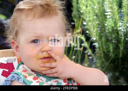 Portrait eine kleine Mädchen mit Essensreste vom füttern um den Mund Stockfoto