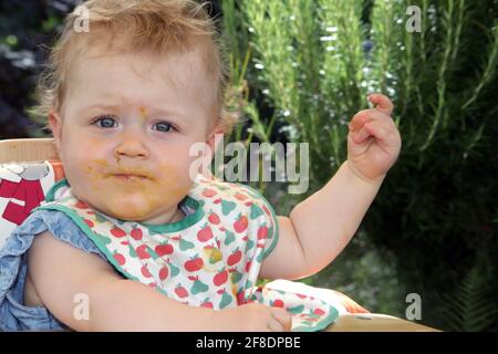 Portrait eine kleine Mädchen mit Essensreste vom füttern um den Mund Stockfoto