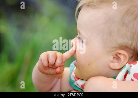 Portrait eine kleine Mädchen mit Essensreste vom füttern um den Mund Stockfoto