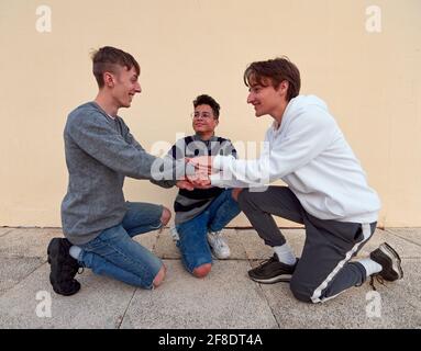 Junge Freunde aus Spanien, die ihre Hände zusammenlegen und haben Spaß an einem Platz im Freien Stockfoto