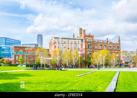 MANCHESTER, GROSSBRITANNIEN, 11. APRIL 2017: Vor der Chethams School of Music in Manchester, England, sitzen Menschen auf Gras Stockfoto