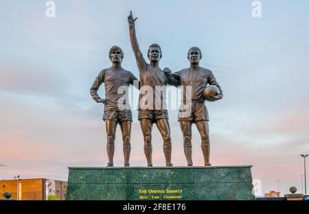 MANCHESTER, GROSSBRITANNIEN, 11. APRIL 2017: Die united trinity Statue vor dem Old trafford Stadium von Manchester United bei Sonnenuntergang, England Stockfoto