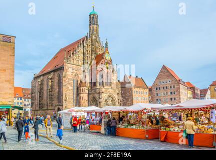 NÜRNBERG, 12. APRIL 2017: Vor der Frauenkirche schlendern die Menschen während des ostermarktes in Nürnberg. Stockfoto