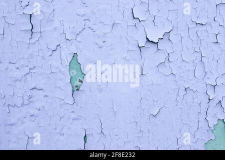 Rissige violette Ölfarbe auf der veralterten Metalloberfläche. Coole Grunge-Knistern-Textur. Gebrochenes Muster. Die Farbe blätterte von der Wand ab. Stockfoto