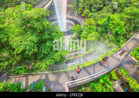 Singapur - 8. Aug 2019: Luftaufnahme der Details von Rain Vortex, dem größten Indoor-Wasserfall der Welt und dem terrassenförmig angelegten Hedge-Labyrinth-Garten im Jewel Airport Stockfoto