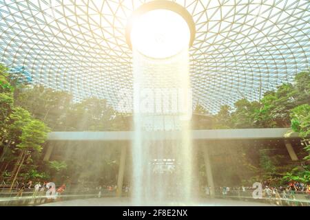 Singapur - 8. Aug 2019: Die Grundebene von Rain Vortex vom Einkaufszentrum im Jewel Airport. Der spektakuläre Wasserfall ist eine neue Touristenattraktion Stockfoto