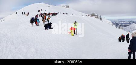 Zakopane - Kasprowy Wierch 23.01.2021 Gruppe von Menschen auf dem Gipfel eines schneebedeckten Berges. Einige warten darauf, dass andere den Gipfel erreichen. Schöner blauer Himmel mit weißen Wolken im Hintergrund. Stockfoto