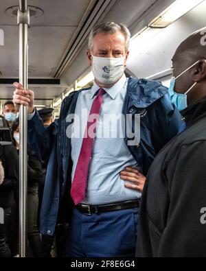 New York, USA. April 2021. Der Bürgermeister von New York City, Bill de Blasio, fährt mit der U-Bahn auf seinen Weg, um gemeinsam mit den Outreach-Mitarbeitern eine Veranstaltung zu organisieren, bei der Gesichtsmasken verteilt und COVID-19-Impftermine in einer spanischen Harlem-Straße eingerichtet werden. Kredit: Enrique Shore/Alamy Live Nachrichten Stockfoto