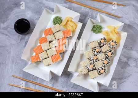 Zwei Sushi-Sets wurden in einem Öko-Behälter aus Papier geliefert. Mittagspause am Arbeitsplatz. Sushi to Go-Konzept. Draufsicht Stockfoto