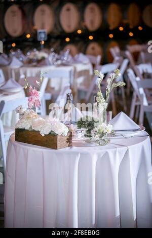 Elegant eingedeckte Tische für ein Abendessen Hochzeitszeremonie mit Kerzen und Blumen als Mittelstücke Stockfoto