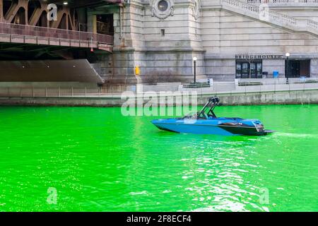 Während der St. Patrick's Day-Party fährt ein Blue and Black Speedboot durch einen grün gefärbten Chicago River Stockfoto