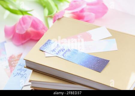 Bücher mit Lesezeichen und Blumen auf hellem Hintergrund Stockfoto