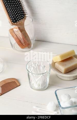 Glas mit Wattestäbchen und Badezubehör auf dem Tisch Badezimmer Stockfoto