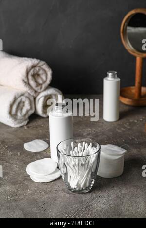 Glas mit Wattestäbchen und Badezubehör auf dem Tisch Badezimmer Stockfoto