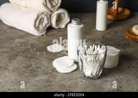 Glas mit Wattestäbchen und Badezubehör auf dem Tisch Badezimmer Stockfoto