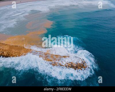 Luftaufnahme des welligen Meeres, das den Strand La Pineda in Tarragona, Spanien trifft Stockfoto