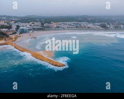Luftaufnahme des welligen Meeres, das den Strand La Pineda in Tarragona, Spanien trifft Stockfoto