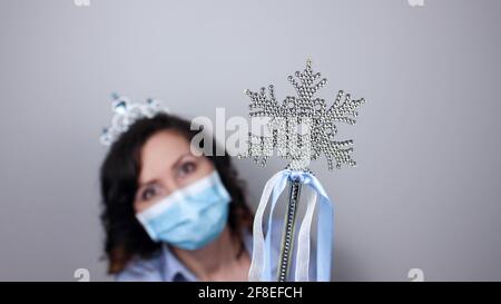 Frau trägt Schutz Gesichtsmaske gegen Coronavirus. Frau in einer Maske und Weihnachtsband. Weihnachten, Halloween Accessoire. Medizinische Maske, Nahaufnahme Stockfoto