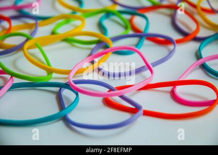 Seitenansicht der bunten Gummibänder auf weiß. Regenbogen Gummibänder auf weiß. Stockfoto