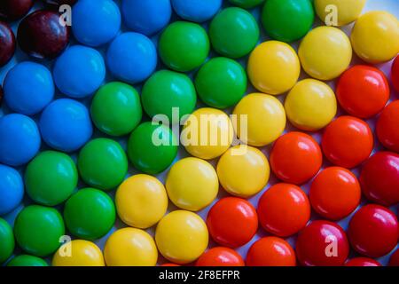 Süße Bonbons in hellen Farben, die flach liegen. Regenbogen Süßigkeiten Hintergrund Stockfoto