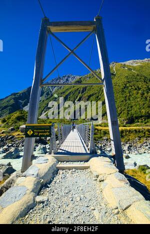 Der Hooker Valley Track ist größtenteils flach und gut geformt, aber einige Abschnitte sind felsig oder schlammig und es gibt drei Schaukelbrücken, die zu überqueren sind. Seien Sie vorbereitet Stockfoto