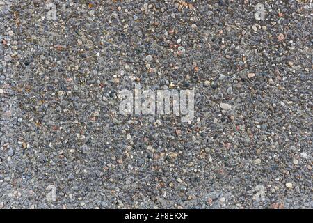 Hintergrund mit grauem Stein und Struktur. Detailreiche kleine Steine an der Wand. Stockfoto