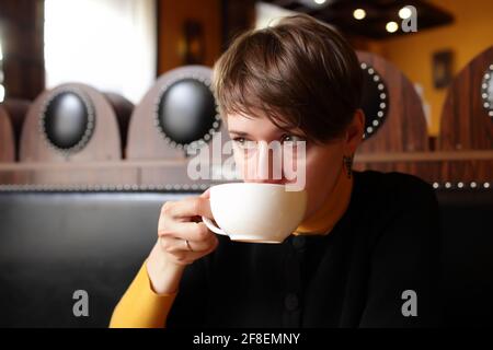 Die Frau trinkt Tee im Restaurant Stockfoto