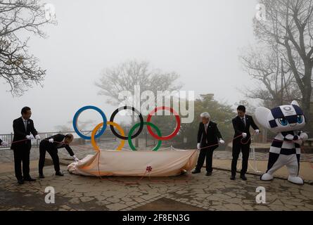 Hachioji, Japan. April 2021. Mitsuchika Tarao (2. L), Vizegouverneur von Tokio, Junichi Miyashita (2. R), Bronzemedaillengewinnerin bei den Olympischen Spielen 2008 in Peking und das Maskottchen Miraitowa 2020 in Tokio enthüllen eine Ausstellung des olympischen Symbols auf dem Berg Mt. Takao in Hachioji, westlich von Tokio, Japan, 14. April 2021, 100 Tage vor dem Beginn der Olympischen Spiele 2020 in Tokio. Quelle: POOL/ZUMA Wire/Alamy Live News Stockfoto