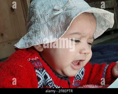 Schöne Kind verschiedene Posen sieht sehr gut aus. Kleines Kind nach der Geburt haben weiche Wangen und unschuldiges kleines Gesicht mit einem strahlenden Lächeln. Stockfoto