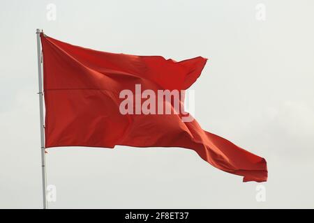 Rote Fahne weht im Wind Stockfoto