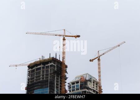 Hochhäuser, die an einem bewölkten Tag im Bau sind. Speicherplatz kopieren Stockfoto
