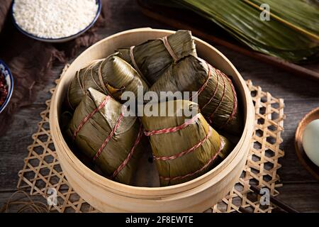 Nahaufnahme einer Schüssel Zongzi auf dem Tisch mit Zutaten darauf Stockfoto