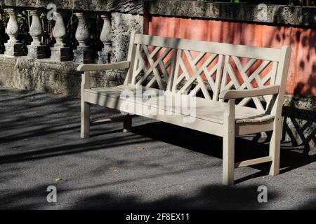 Vintage weiße Holzparkbank mit Schatten. Stockfoto