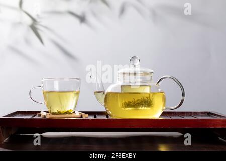 Nahaufnahme einer Glas-Teekannen und einer Tasse mit Grün Tee auf einem Tablett auf dem Tisch Stockfoto