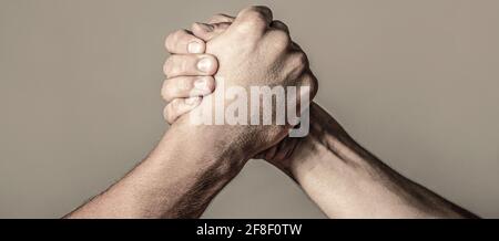 Armdrücken. Nahaufnahme. Freundlicher Händedruck, Freundschaftsgrüße, Teamarbeit, Freundschaft. Handschlag, Waffen, Freundschaft. Handrivalität vs Herausforderung Stärke Stockfoto