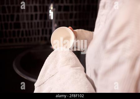 Hausfrau wischt Geschirr mit weißem Handtuch in der schwarzen Küche bei Zu Hause Stockfoto