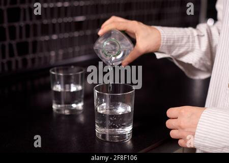 Frau Hand halten Flasche mit Wasser. Gesunden Start des Morgens mit sauberem Wasser Stockfoto