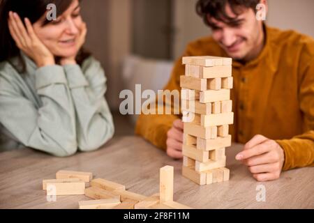 Paar spielen Jenga Blöcke zu Hause. Hängen mit Freunden während der Quarantänesperre - Odessa, Ukraine - 04/02/2021 Stockfoto