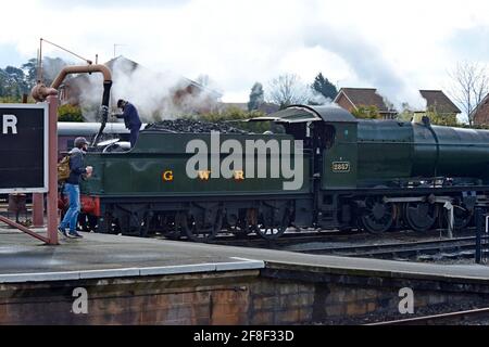 Der Dampfzugfahrer füllt die ehemalige Great Western Lok 2857 mit Wasser am Bahnhof Kidderminster, Severn Valley Railway Stockfoto